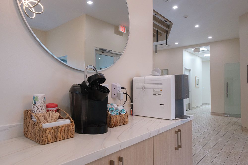Keurig and supplies on counter in waiting area for clients